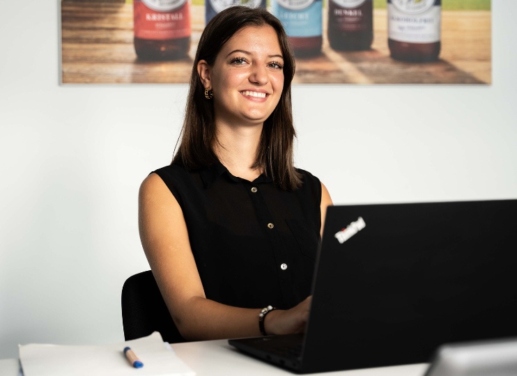 Auszubildende Kauffrau für Tourismus und Freizeit bei Maisel & Friends arbeitet am Laptop und plant neue Erlebnisse