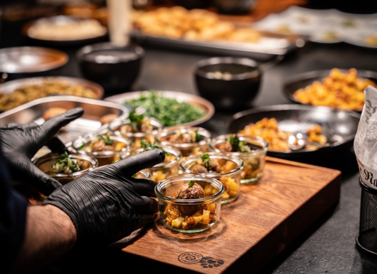 Köche und Köchinnen bei Maisel & Friends bereiten kreative Gerichte mit frischen Zutaten in der Küche zu