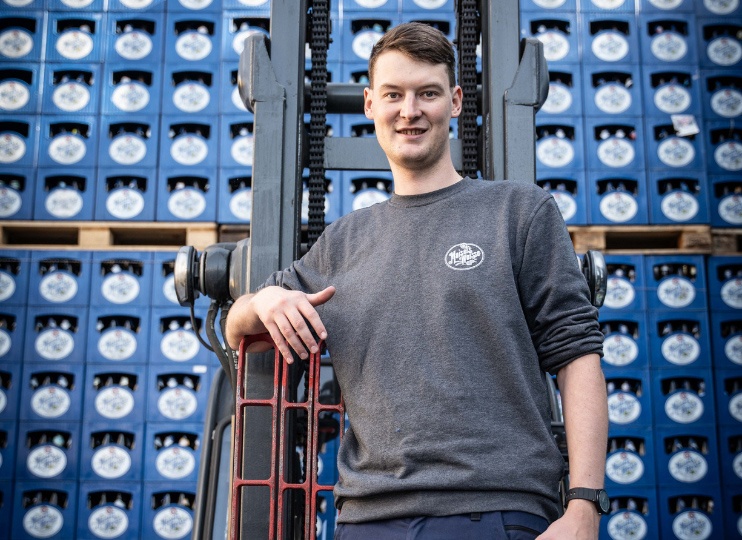 Auszubildender Fachkraft für Lagerlogistik bei Maisel & Friends arbeitet mit dem Gabelstapler im Brauereilager