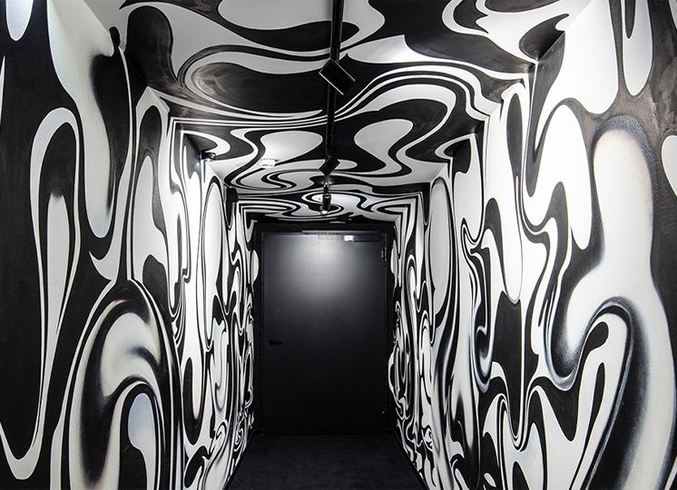 A corridor painted with a black and white pattern in the Urban Art Hotel