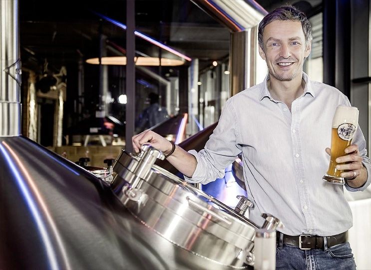 Owner Jeff Maisel in the brewery holding a glass of Maisel's Weisse wheat beer