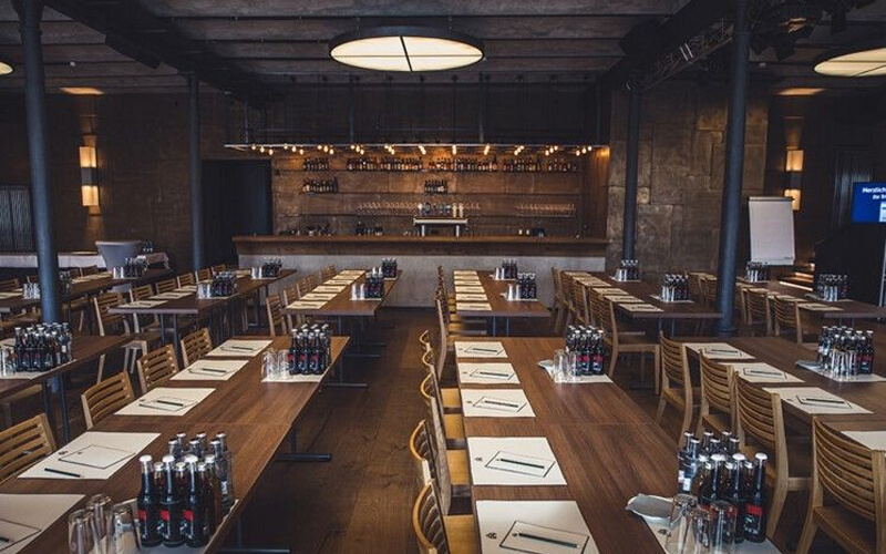 Konferenzraum mit Reihenbestuhlung, Tischen und Getränken, vorbereitet für ein Seminar