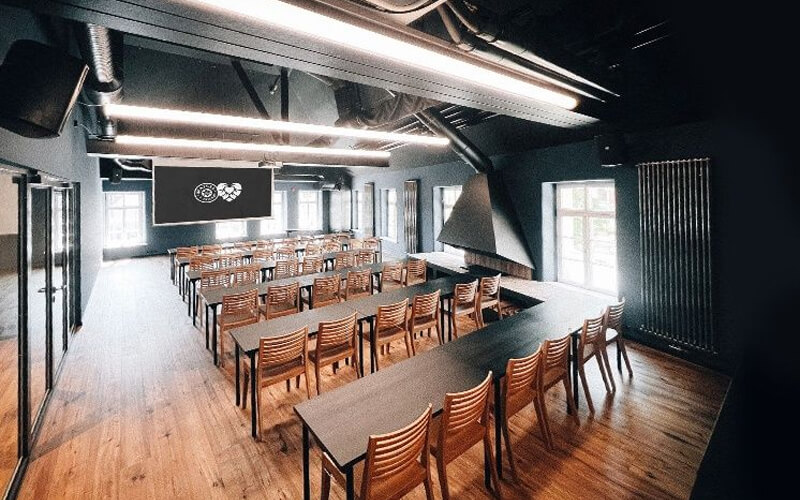 Seminarraum mit Reihenbestuhlung und Präsentationsfläche in modernem Industriedesign