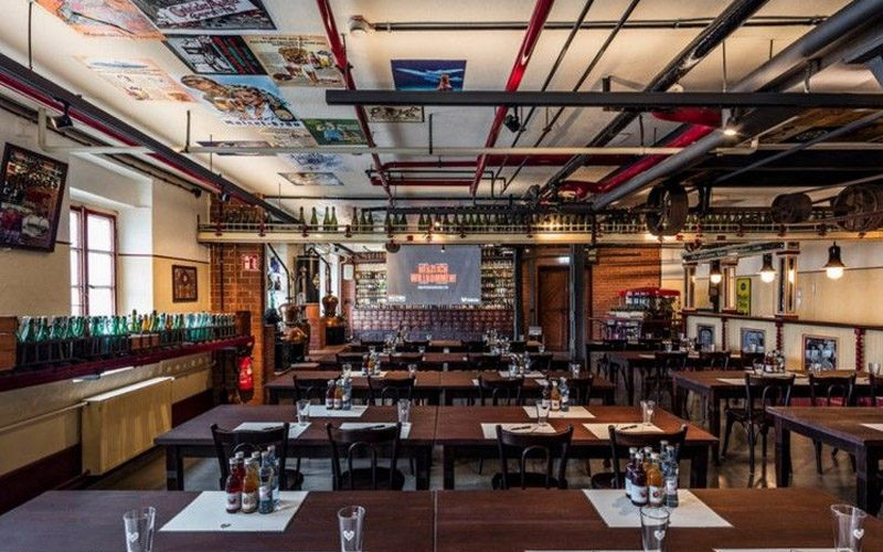 Großer Veranstaltungsraum mit Tischen, Getränken und Präsentationsfläche